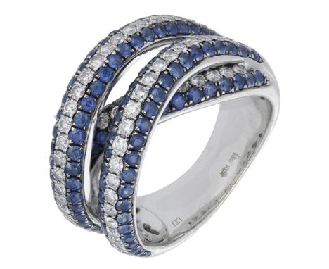 A sapphire and diamond dress ring, of crossover design, pavé-set to the front with a combination of circular-cut sapphires an