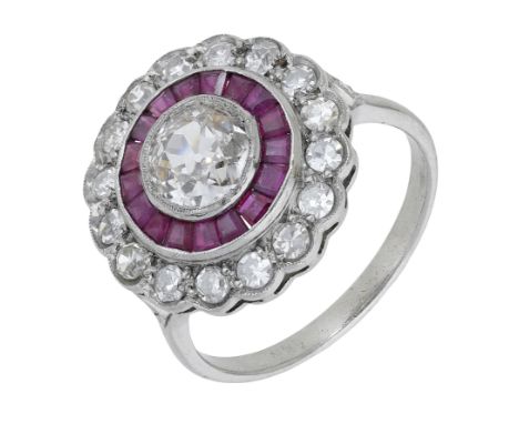 A diamond and ruby cluster ring, of target design, the central old cushion-cut diamond millegrain set within a scalloped surr