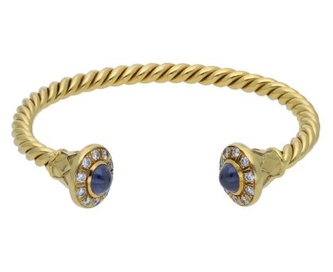 An 18ct gold sapphire and diamond torque bangle, 1986, the ropetwist bangle with fanned terminals, each with harlequin style 