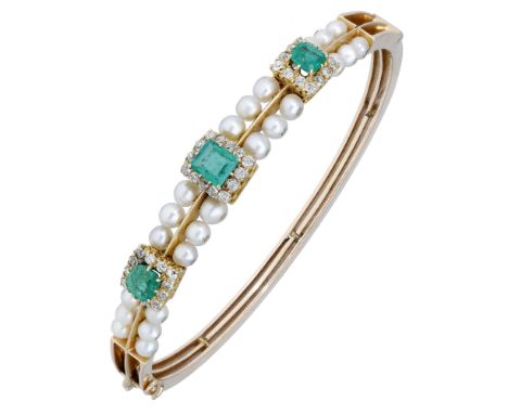 A late 19th century emerald and pearl bangle, set to the front with a central step-cut emerald within a surround of old brill