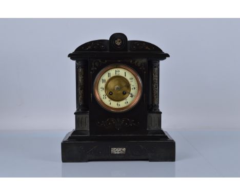 A slate mantle clock, with enamel and brass dial, marble pillars and inlay. Brass chiming movement stamped 1613 48. 35cm tall