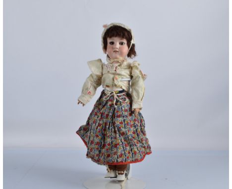 An Armand Marseille 390 child doll, with brown sleeping eyes, brown mohair wig, jointed composition body, floral print skirt,