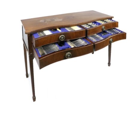 An Edwardian mahogany Table Canteen of silver Cutlery, the plain top above a serpentine front with four frieze drawers, with 