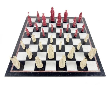 An important and fine quality 19th Century carved red and white Chess Set, decorated in the Oriental form, with figures in ty