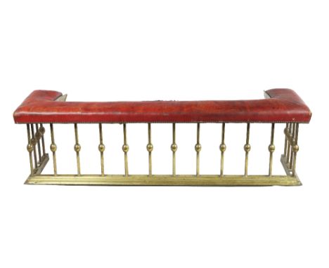 An early brass Club Fender, with red leather seat, and tubular uprights on shaped base, approx. 155cms (61") wide. (1)