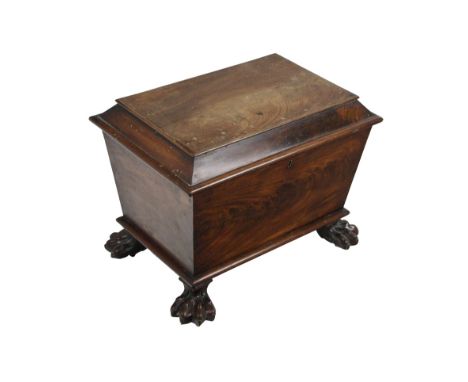 A 19th Century Irish mahogany sarcophagus shaped Cellarette, the hinged top opening to reveal a fitted interior on four carve