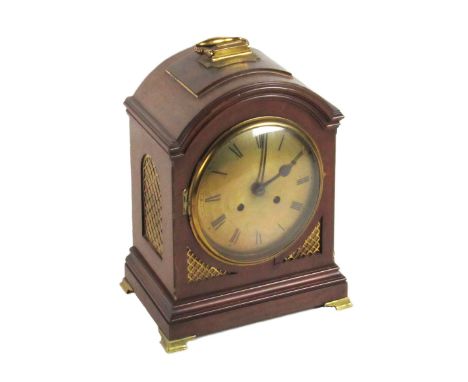 A late 19th Century mahogany Bracket or Mantle Clock, the arched top with brass carrying handle, over a circular brass dial w