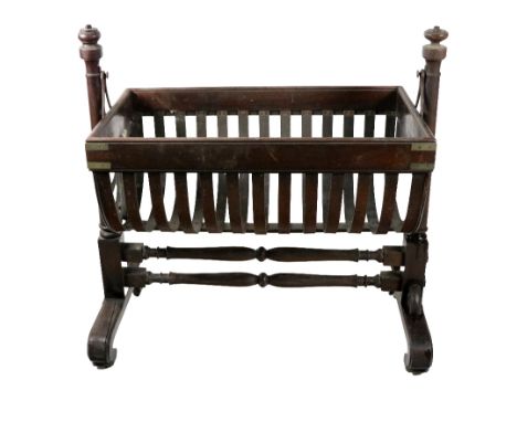 A 19th Century mahogany Cradle, of boat form with brass straps and latted supports, with turned pillar uprights and stretcher