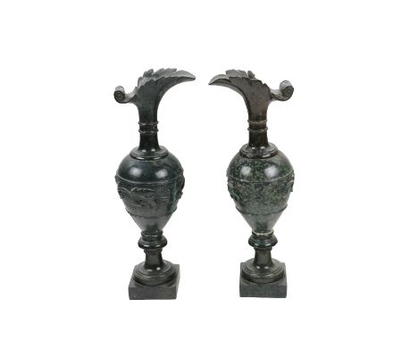 An attractive pair of carved marble Archaic style Ewers, each with shaped lip and decorated with vine leaves on square bases,