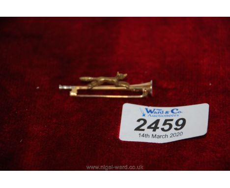 A 15 ct. Gold tie pin in the shape of a hunting horn with running fox.