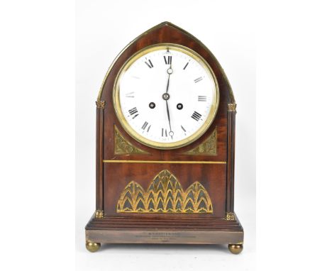 An Edwardian mahogany mantle clock, Regency inspired with pierced gilt metal grilles, twin lion ring handles, the convex 6" d