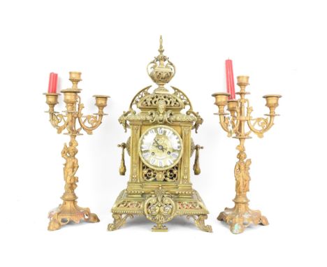 A late 19th century French gilt metal 8 day mantle clock with two spelter figural garnitures, the clock having an urn formed 