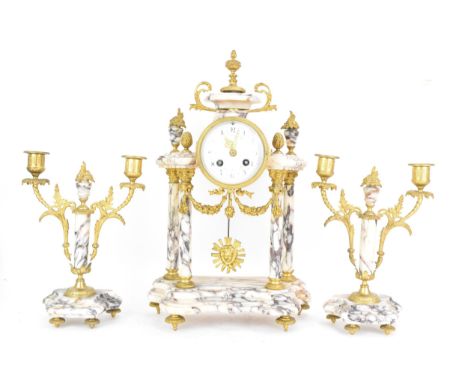 A late 19th century French marble and gilt metal clock garniture, the clock or architectural form with four turned Corinthian