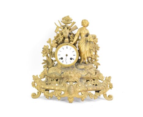 A late 19th century French spelter mantle clock, the gilded case fashioned as a shepherdess leaning against the drum shaped c