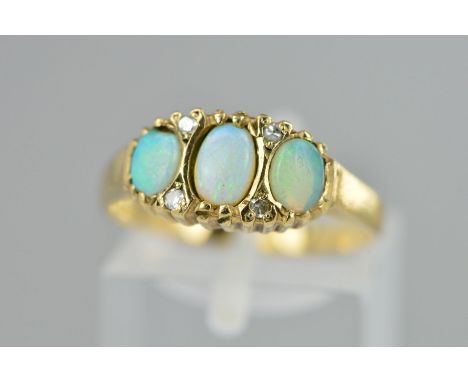 A 9CT GOLD OPAL AND DIAMOND RING, designed as three oval opal cabochons each interspaced by two single cut diamonds, hallmark