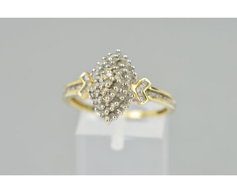 A 9CT GOLD DIAMOND DRESS RING, the tiered central panel set with single cut diamonds, the arrow shape shoulders set with bagu