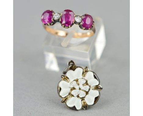 A RUBY AND DIAMOND RING AND AN ENAMEL CHARM, the ring designed as three graduated oval rubies interspaced by two brilliant cu