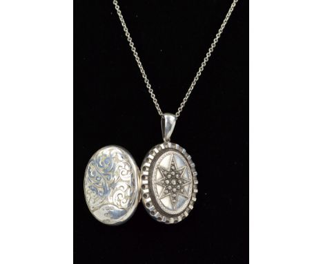 A MID VICTORIAN SILVER LOCKET AND LATER CHAIN, of oval outline with central embossed star to the front and engraved scrolling