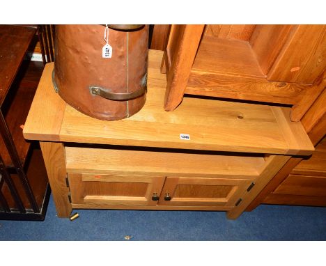 A LIGHT OAK CORNER TV STAND with double cupboard doors, approximate width 94cm