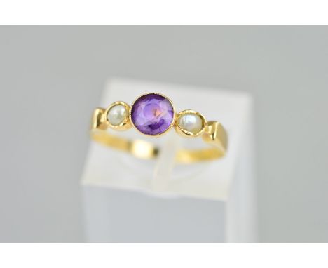 AN EARLY 20TH CENTURY AMETHYST AND PEARL RING, the central circular amethyst flanked by a split pearl and a replacement imita