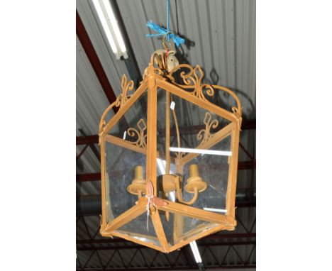 A WROUGHT IRON SQUARE TAPERING LANTERN with a scrolled top and electrical wiring