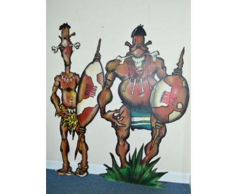 TWO PLYWOOD THEATRE PROPS IN THE FORM OF TWO COMICAL TRIBAL WARRIORS, painted with bones through noses, holding shields and s