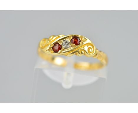 A LATE VICTORIAN 18CT GOLD RUBY AND DIAMOND RING the front panel of scrolling design set with two circular rubies and an old 