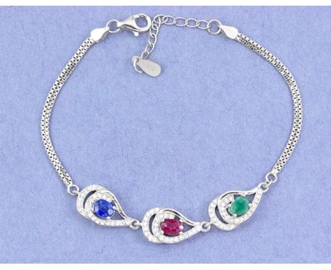 A 925 silver bracelet set with oval cut emerald, ruby and sapphire surrounded by white stones, L. 16cm.