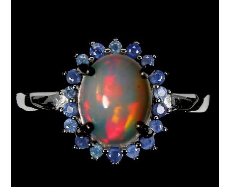 A 925 silver cluster ring set with cabochon cut opal surrounded by sapphires, (Q).