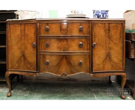 A Beithcraft Furniture serpentine front sideboard, three central drawers flanked by cupboards enclosing one shelf, ornate bra