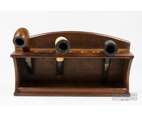 A wooden smokers' pipe rack, and three pipes (4)