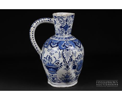 A Dutch delftware blue & white ewer, painted with baskets of foliage under stiff leaf pendant border, conjoined AK mark to ba
