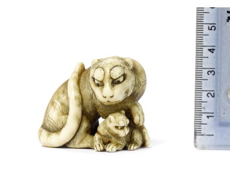 An ivory netsuke of a tigress and cubSchool of Tomotada, Kyoto, late 18th centuryThe mother seated, her head turned to the ri