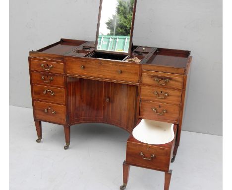 A Georgian mahogany gentleman's dressing table/cabinet, in the manner of Gillows, with two-piece hinged top revealing a serie