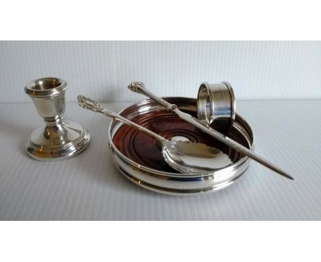 A contemporary silver wine coaster, single dwarf candlestick, napkin ring, preserve spoon and a letter opener (5) 