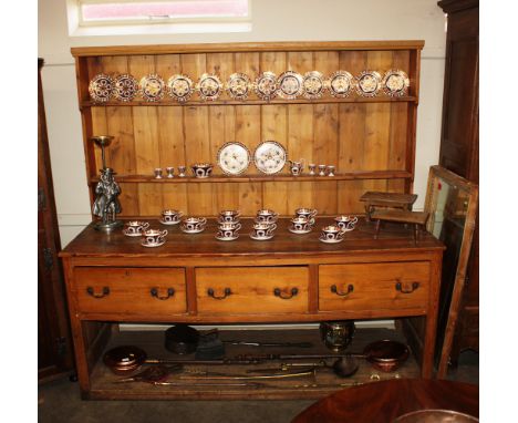 A large stripped pine kitchen dresser, having shelf and boarded plate rack above three deep drawers, pot board below, 210cm w