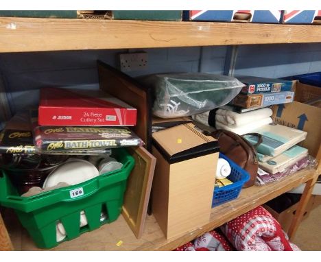 A shelf of miscellaneous; towels, bedding, china etc.