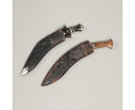 A Kukri knife with a shaped 30cm blade with pricked decoration, in a black leather sheath with two subsidiary knives, a simil