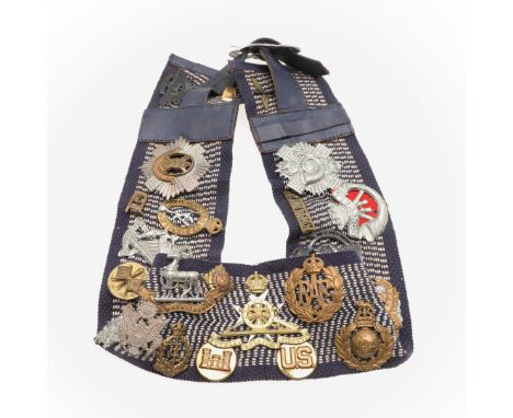 A collection of twenty seven badges to include a silver Royal Armoured Corps cap badge, hallmarked for Birmingham 1941, other