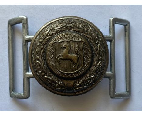 A Second World War German Army belt buckle, early aluminium pebbled design type, with an Eagle in the center holding a swasti