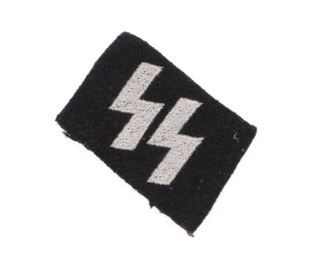 A collar patch with twin runes in pale grey cotton on a black felt backing, probably removed from a tunic, 3.5 x 5cm. *CR Goo