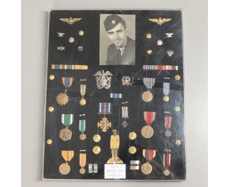 A mounted collection of medals and insignia attributed to commander Rolfe W. Crowley of the United States Navy. Including Ame