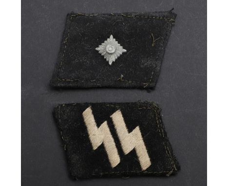 Two black felt collar patches, both on black felt, one with machine woven pale grey SS runes, the left patch with a single me