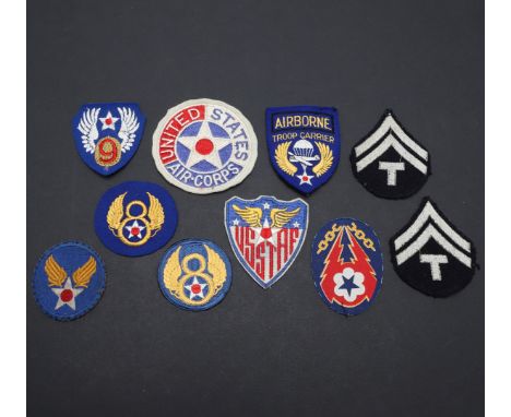 An unusual British made, printed European Theater U.S. Airborne patch, two 8th Airforce patches, a 9th , Troop carrier badge 