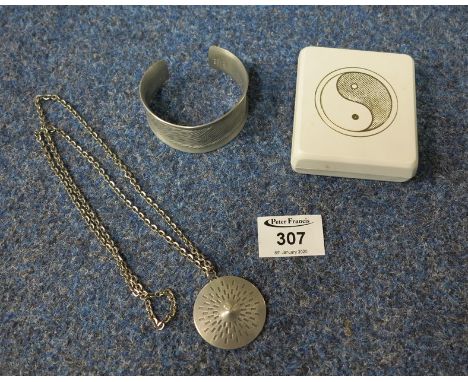 Three pieces of mid Century pewter jewellery by Jorgan Jensen, Bangle no. 986, Yin og Yan pendant no. 295 and pendant no. 51.