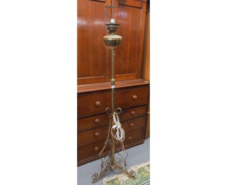 Brass standard oil lamp with telescopic pedestal and scroll work triform base, converted to electricity. (B.P. 24% incl. VAT)