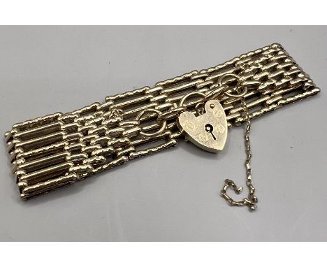 A vintage 9ct gold gate bracelet with a heart shaped padlock charm. Approximately 18cms in length, 2.2cm in width. Gross weig
