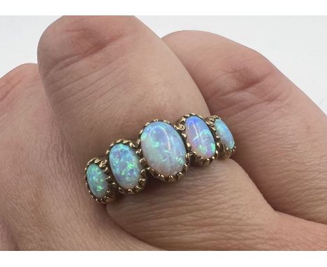 A 9ct gold opal five stone ring, set with five graduated cabochons of opal n closed-back milgrain setting. Size N. Gross appr