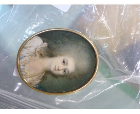 A PORTRAIT MINIATURE OF AN 18TH CENTURY LADY WITH GREY POWDERED HAIR, THE GILT OVAL FRAME WITH MOTHER OF PEARL BACK.   H 5cms