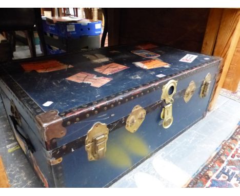 A VINTAGE BLUE CABIN TRUNK WITH IRON PROTECTED CORNERS AND OLD LABELLING. W 91cms.